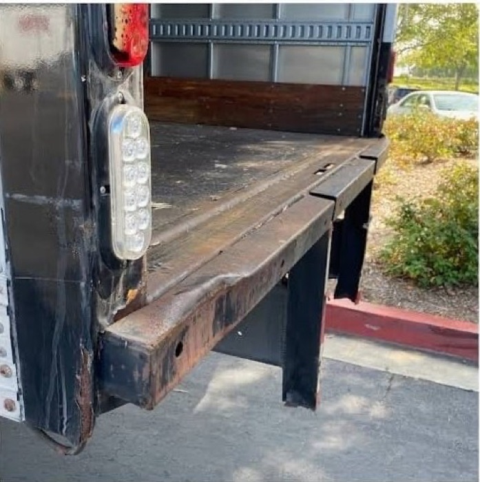 Another angle of the rusted, bent rear bumper and frame