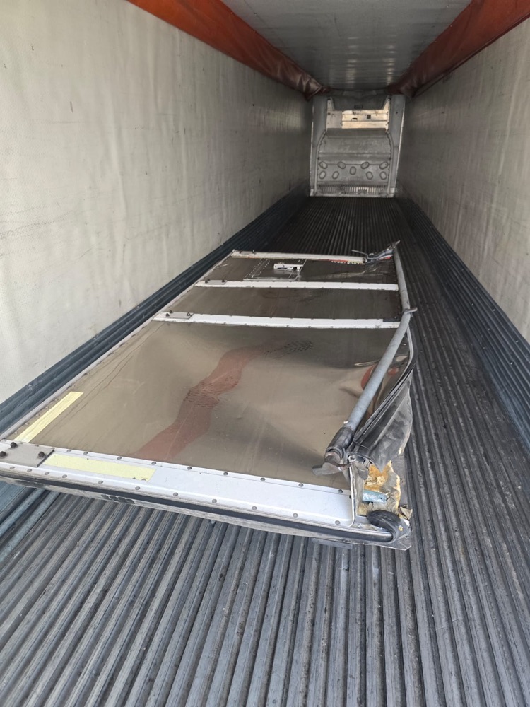 Damaged door removed and lying inside the trailer