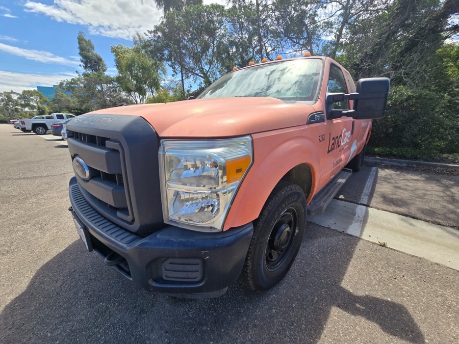 Orange Ford F-350 pickup with sun-faded paint on the hood and fender
