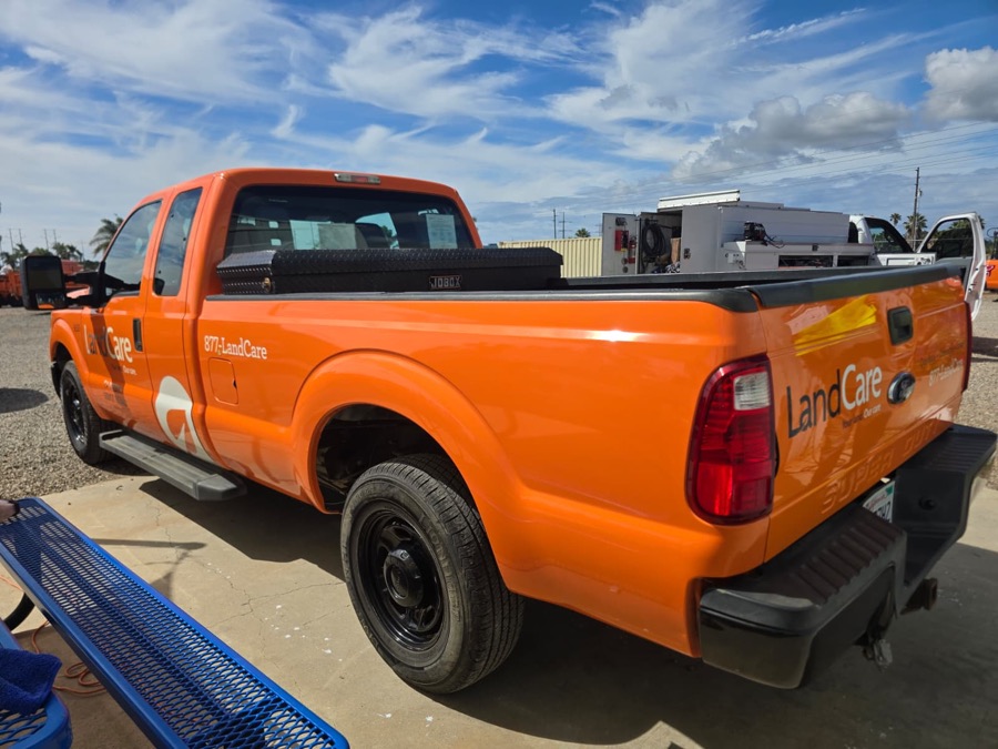 Refinished orange F-350 pickup, rear three-quarter view