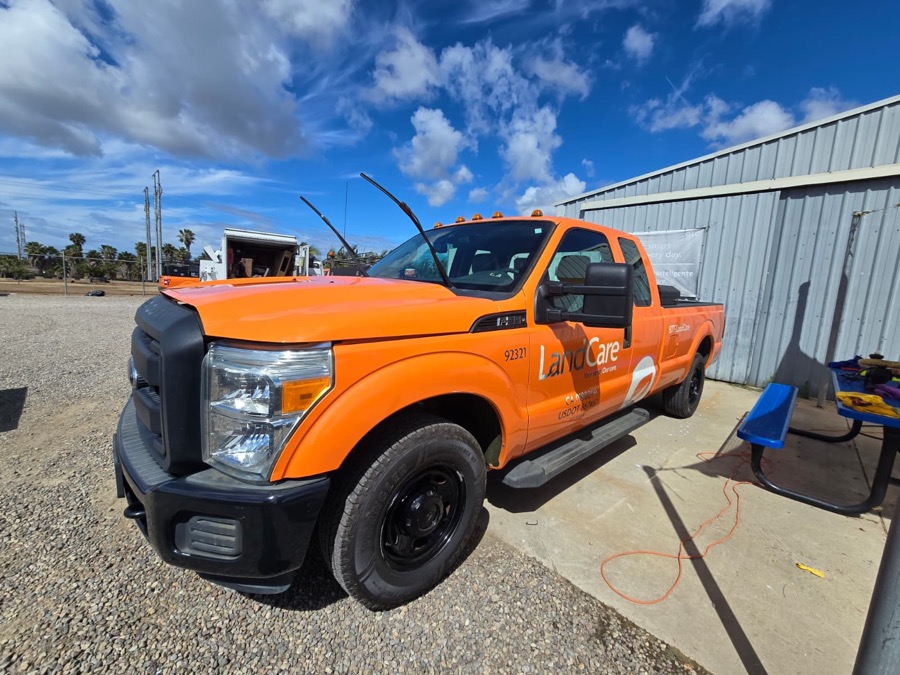 Refinished orange F-350 pickup with fresh paint and the wipers lifted