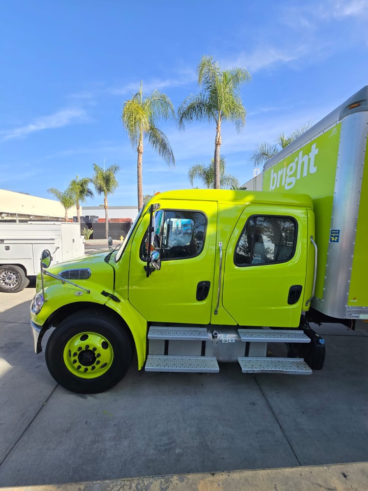 Side view of a lime green box truck cab after paint work