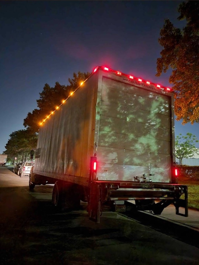 Box truck lit with red LED marker lights at night