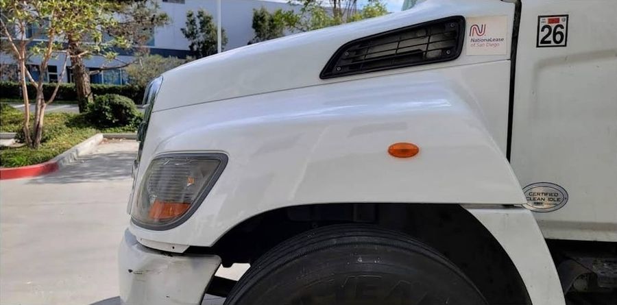 Same white Hino truck after the fender and bumper were repaired and refinished