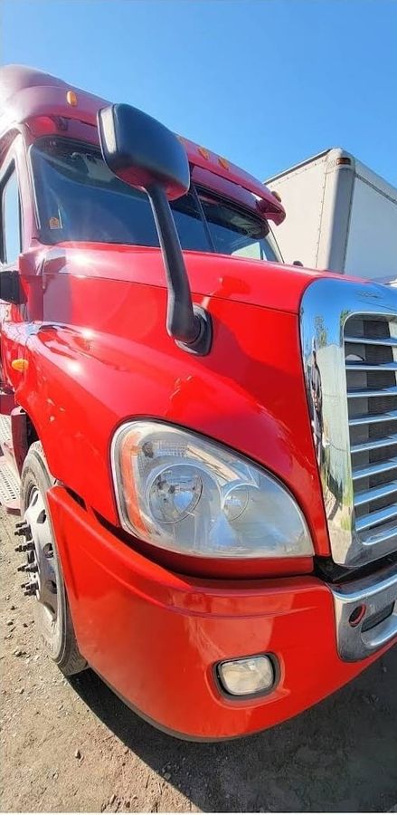 Same red Freightliner tractor after repair, fender and bumper refinished