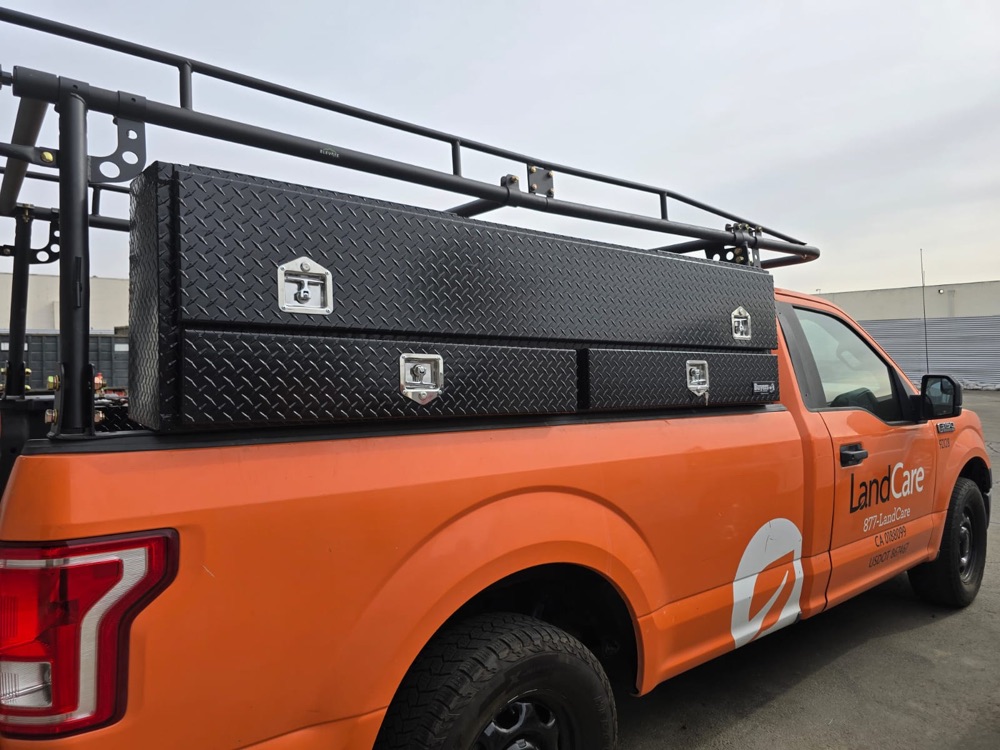 Pickup with a lumber rack and diamond plate toolboxes installed, side view