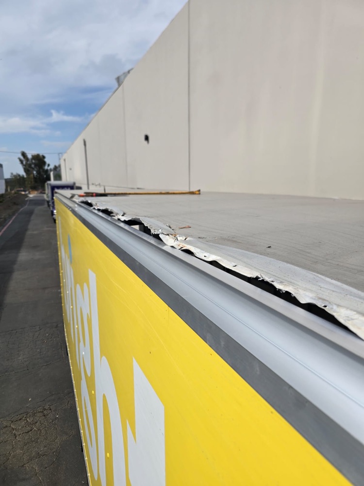 Close-up of the torn top rail section on a box truck