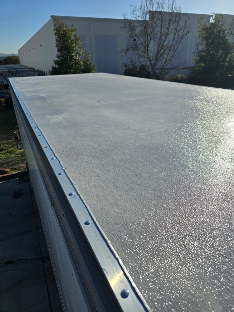 Finished box truck roof with a smooth textured coating sealed right up to the aluminum edge rail