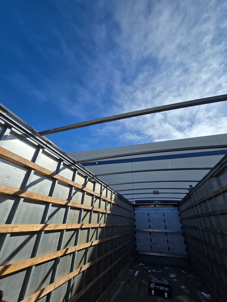 Open-top box truck frame with the old roof removed and the roof bows exposed