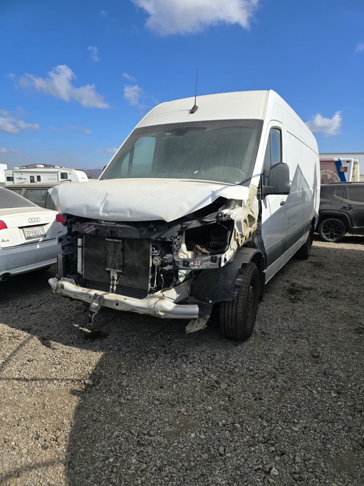 White Mercedes Sprinter van with a crushed hood and torn-off front end