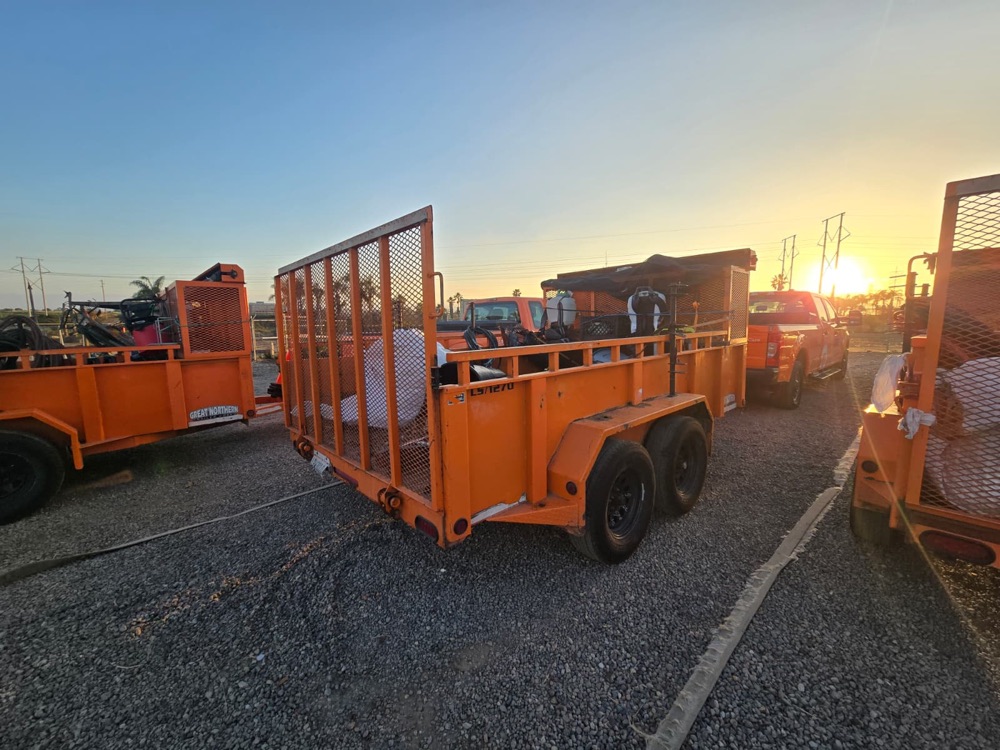 Orange tandem-axle utility trailer at sunset