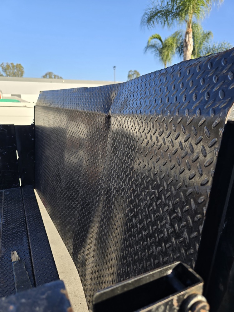 Dented diamond plate truck bed side before repair